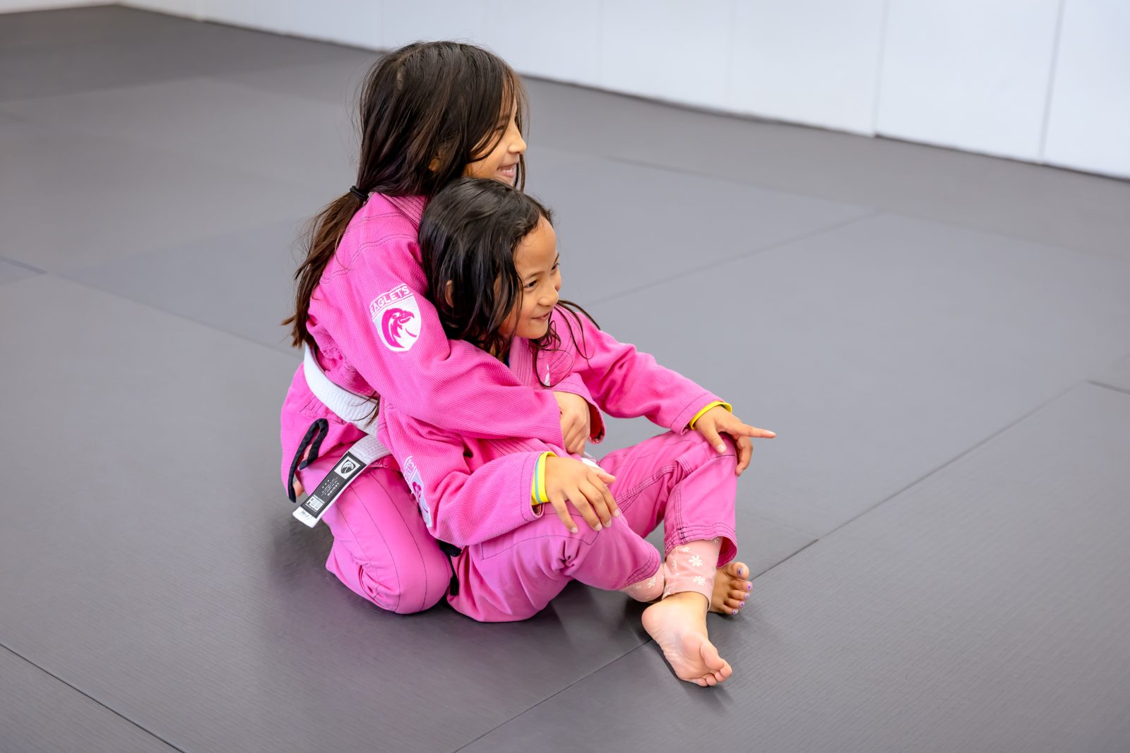 Two siblings training together on the mat